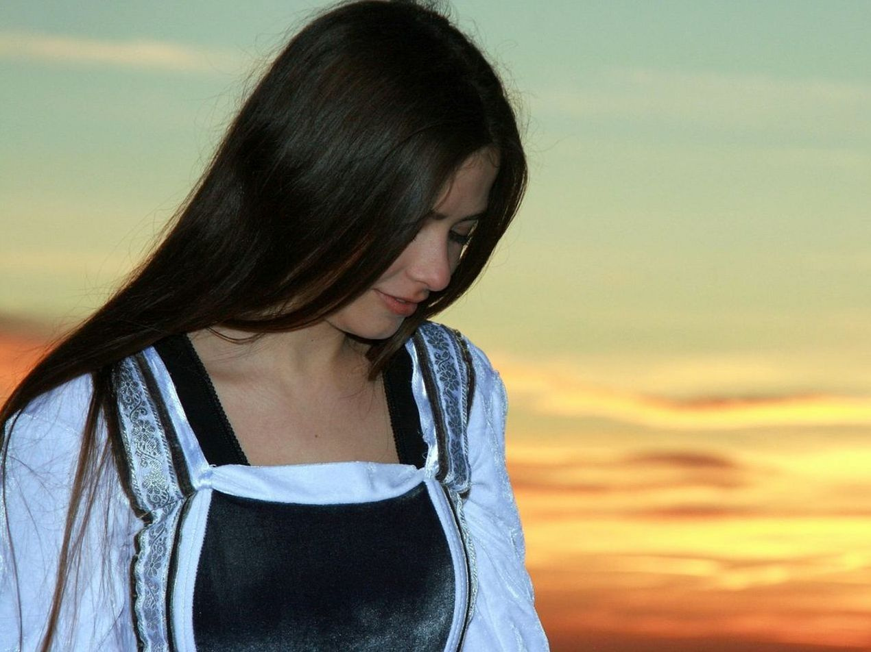 Mat bir ışıkla aydınlanmış, ince oyma izleri taşıyan uzun bir antik heykel